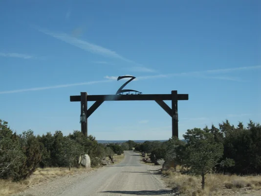 Vue aérienne du Zorro Ranch, un vaste domaine beige entouré de verdure et de routes rurales.
