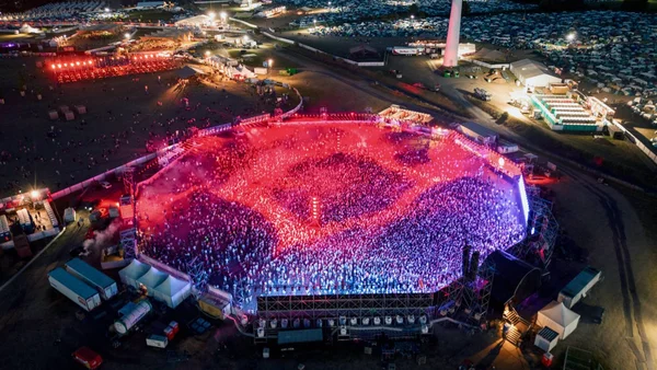 Une grande foule rassemblée devant la scène du Dour Festival sous un ciel partiellement nuageux.