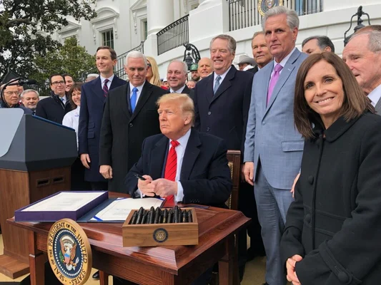 Donald Trump signe l'USMCA, une victoire historique pour les travailleurs américains, entouré de sénateurs.