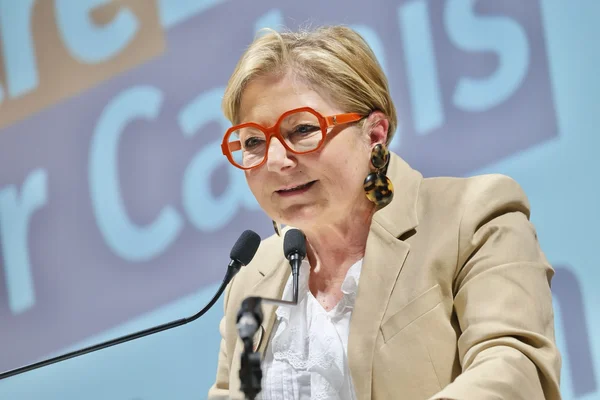 Natacha Bouchart en blazer beige lors d'une allocution publique derrière un pupitre.