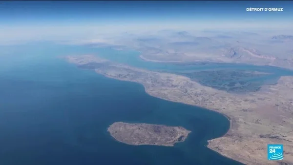 Vue aérienne du détroit d'Ormuz, un passage maritime étroit entre des terres arides et une île.