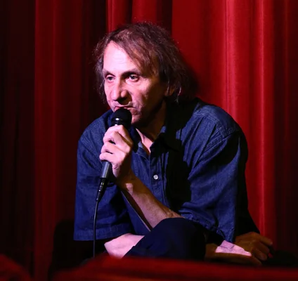 Michel Houellebecq tenant un micro lors d'une conférence.