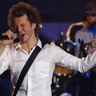 Sinclair en concert interprétant un titre au micro.