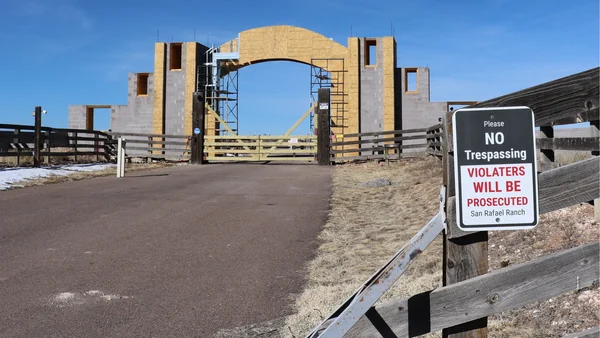 Panneau San Rafael Ranch avec construction en arrière-plan.