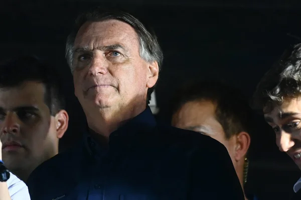 Jair Bolsonaro en chemise bleue foncé debout dans la foule.