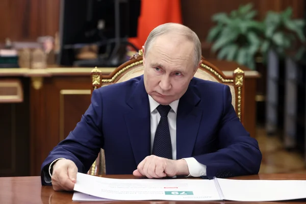 Vladimir Poutine à son tenant lisant un document officiel.