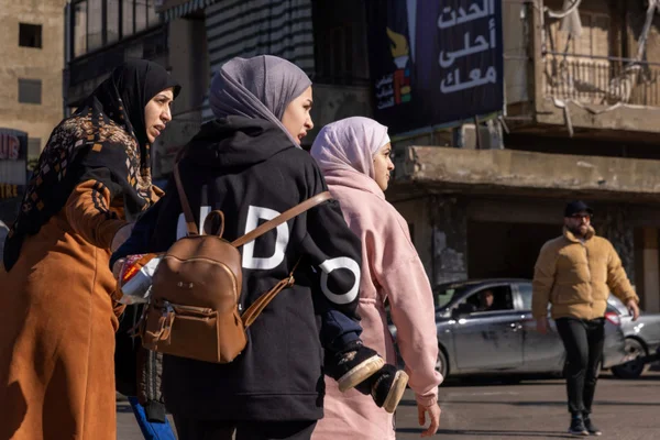 Résidentes portant des sacs à dos marchant dans les rues suite à l'appel à évacuer.