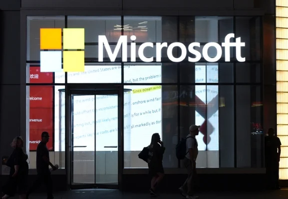 Devanture de magasin Microsoft de nuit avec passants.