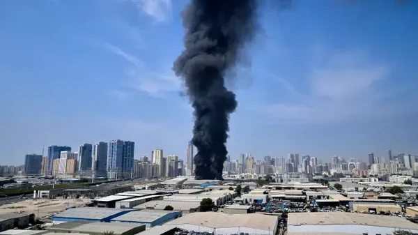 Un incendie avec une épaisse fumée noire dans une zone urbaine