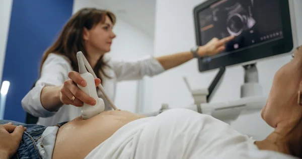 Un professionnel de santé effectue une échographie sur le ventre d'une patiente.