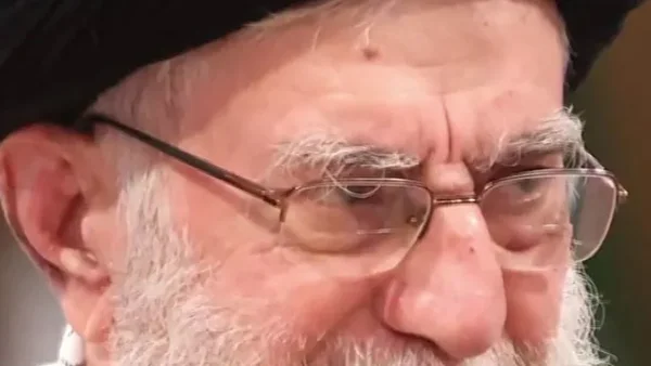 Un gros plan d'une personne avec une barbe blanche et des lunettes.