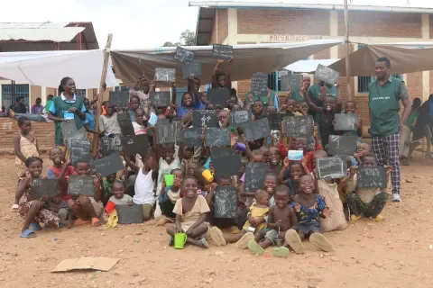 Jeunes réfugiés et adultes participant à une activité éducative dans le camp.