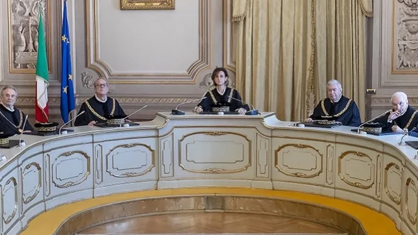 Groupe de juges en robe officielle assis devant des drapeaux italiens