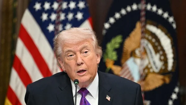 Donald Trump s'adressant à la presse devant un drapeau américain.