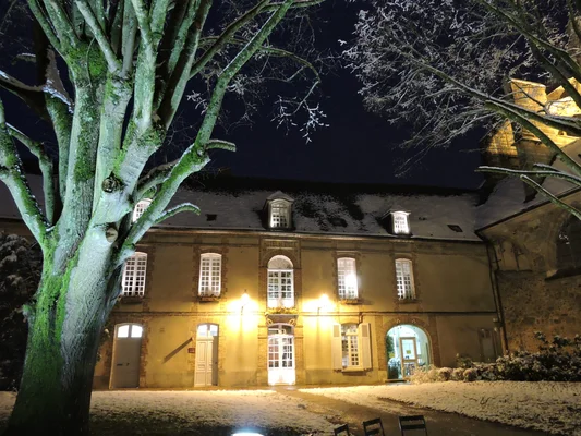 Vue nocturne de l'Hôtel de ville de Sézanne sous la neige, avec ses fenêtres éclairées.