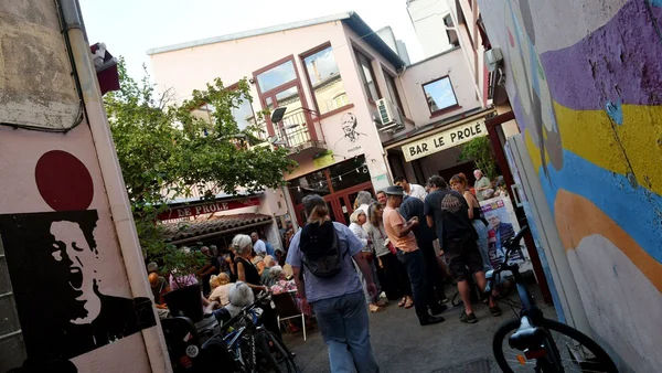 Une foule la nuit tenant des torches et des drapeaux dans une ambiance intense.