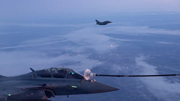 Un ravitaillement en vol d'un Rafale au-dessus d'une couche nuageuse.