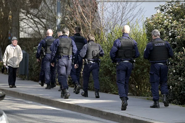 Des policiers patrouillant dans un quartier de Villeurbanne après les coups de feu, sous le regard d'un résident.