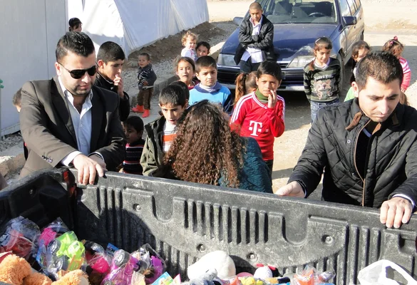 Jeune aux cheveux roux bouclés assis sur un véhicule, regardant vers le haut devant un drapeau tricolore.