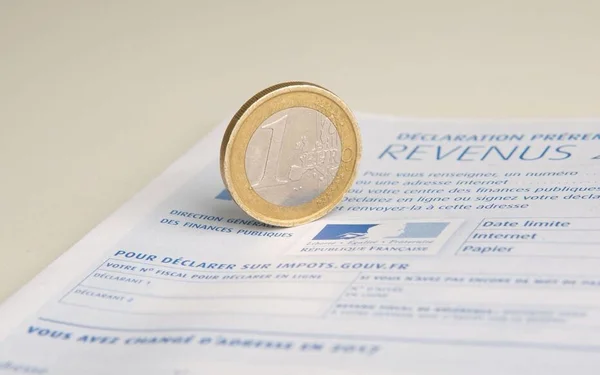 Une pièce d'un euro sur un formulaire de déclaration de revenus.