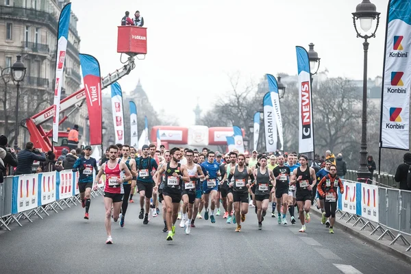 Groupes de coureurs lors du Semi-marathon de Paris sur une rue urbaine.