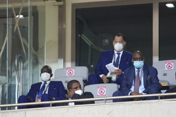 Des dirigeants de la CAF respectant les mesures barrières dans la tribune d'un stade.