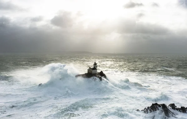 Le phare du Tévennec face à une mer déchaînée et un ciel menaçant.