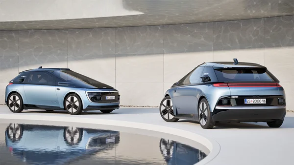 Deux modèles du robotaxi Verne stationnés dans un environnement architectural minimaliste.