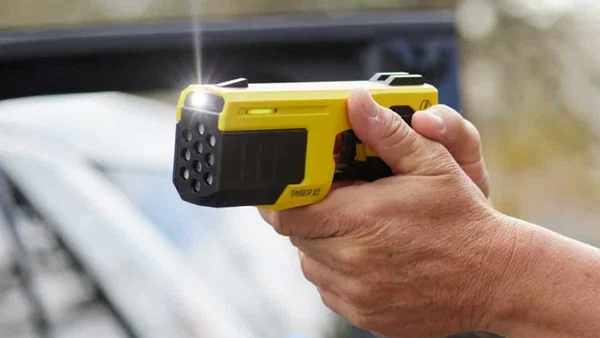 Un pistolet à impulsions électriques de type Taser tenu en main.
