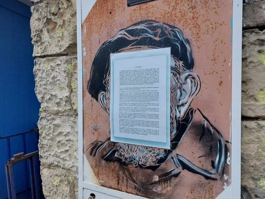 Fresque d'un homme partiellement masquée par un document officiel.
