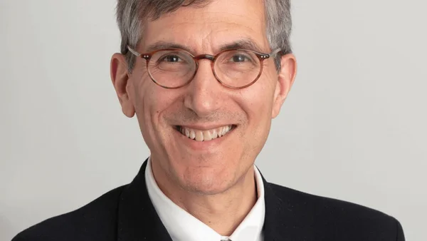 Peter Mills intervenant dans le cadre d'un journal télévisé sur fond urbain.