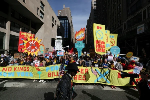 Manifestation « No Kings» à New York avec des pancartes « NO KINGS NEW YORK» et « WE ARE THE POWER» devant des gratte-ciel.