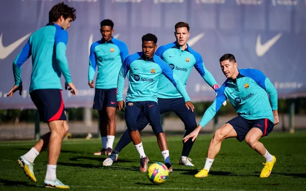 Cinq joueurs du Barça en tenue d'entraînement lors d'un exercice technique avec un ballon.