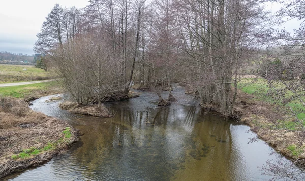 La rivière Argence serpentant à travers un paysage brumeux du plateau de l'Aubrac.