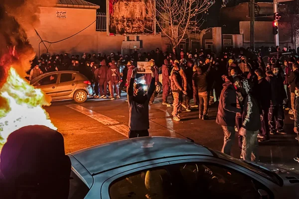 Foule la nuit avec un panneau et un feu de rue