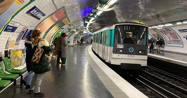 Rame de métro à la station Arts et Métiers avec des passagers sur le quai.