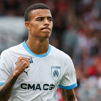 Mason Greenwood célébrant un but au stade avec le poing levé, sous le maillot de l'Olympique de Marseille.