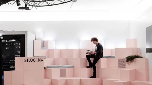 Un jeune lisant un livre sur les structures en cubes roses du Studio 13/16 au Centre Pompidou.