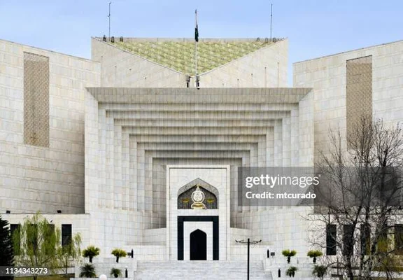 La façade imposante de la Cour suprême du Pakistan avec son architecture en pierre et son drapeau national.