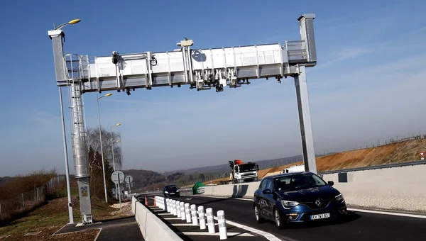 Voiture franchissant un portique de péage sans barrière sur une autoroute française.