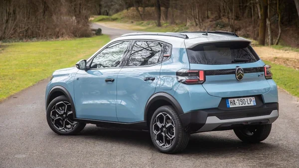 Un SUV Citroën bleu clair stationné au bord d'une route ombragée, immatriculé en France.