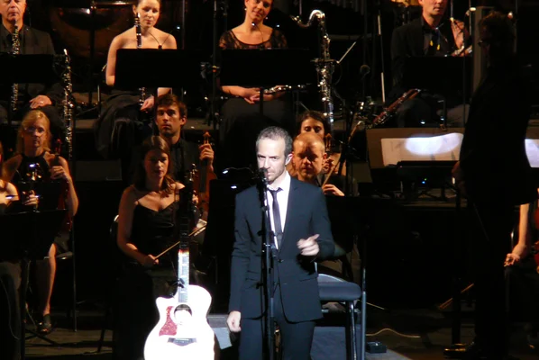 Calogero jouant de la guitare sur scène lors de sa tournée symphonique au Théâtre du Châtelet en 2011.
