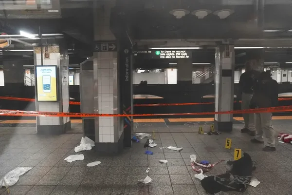Scène de crime sur un quai de métro isolé par un ruban de police orange avec des marqueurs d'évidence au sol.