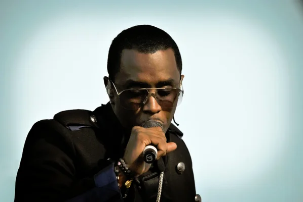 Sean Combs lors d'un entretien en 2023, portant des lunettes de soleil et une chemise grise.