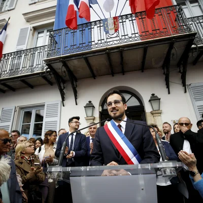 Le maire RN de Cagnes-sur-Mer s'exprimant devant la mairie, écharpe tricolore au cou, sous les applaudissements des habitants.