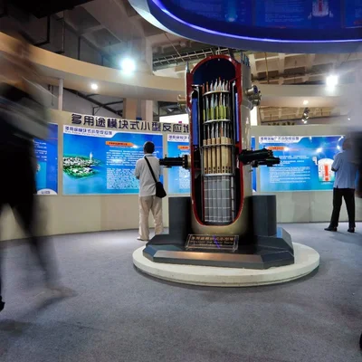 Visite d'une exposition présentant une maquette détaillée d'un mini-réacteur nucléaire (SMR).