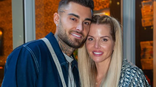 Thibault Garcia aux côtés de sa nouvelle conquête blonde, dans une tenue à imprimé, sous un éclairage chaleureux.