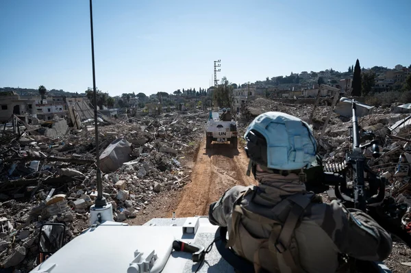 Militaire français de la Finul en observation depuis son véhicule, face à des ruines dans le Sud-Liban.