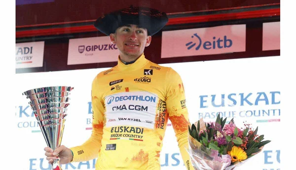 Paul Seixas célébrant sa victoire avec le trophée et un bouquet de fleurs.