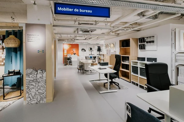 Rayon mobilier de bureau IKEA avec bureaux et signalétique bleue.